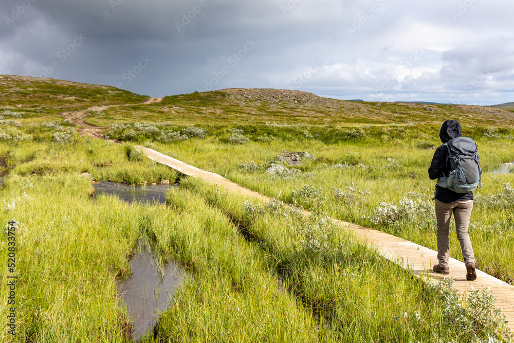 Woman walks on the  path leading to the Sautso Canyon Alta, Finnmark, Norway.