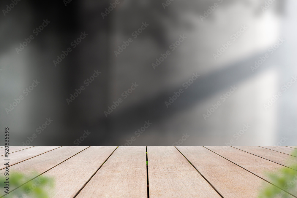 Empty old wooden table in front of blurred background of cement wall with shadow of leaf and sunlight. Can be used for display or montage for show your products. Empty old wooden table in front of blurred background of cement wall with shadow of leaf and sunlight. Can be used for display or montage for show your products.