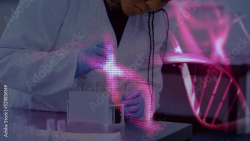 Animation of dna strands over african american female scientist in lab photo