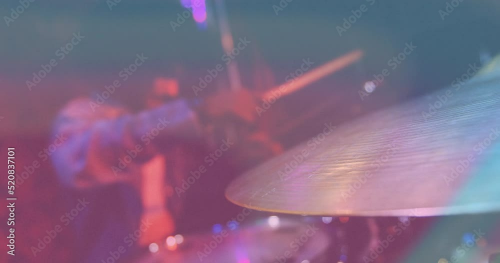 Video of african american male drummer playing drum kit, cymbal in foreground