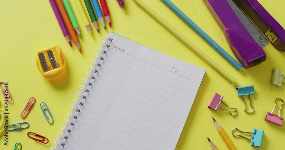 Video of school supplies and notebooks, paper clips, pens over yellow background Video of school supplies and notebooks, paper clips, pens over yellow background