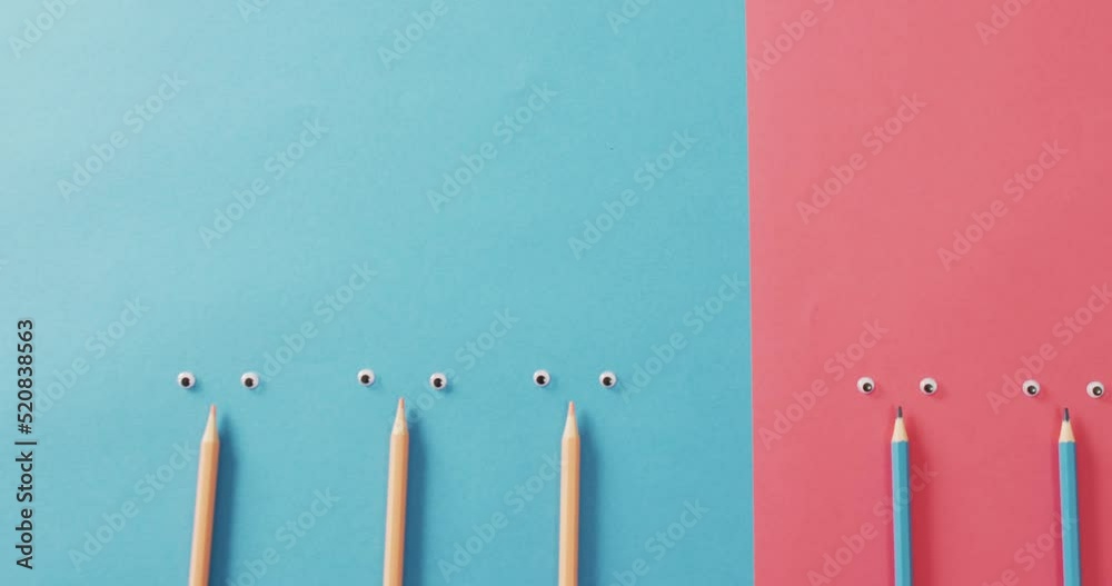 Video of composition with crayons and eyes on blue and pink surface Video of composition with crayons and eyes on blue and pink surface