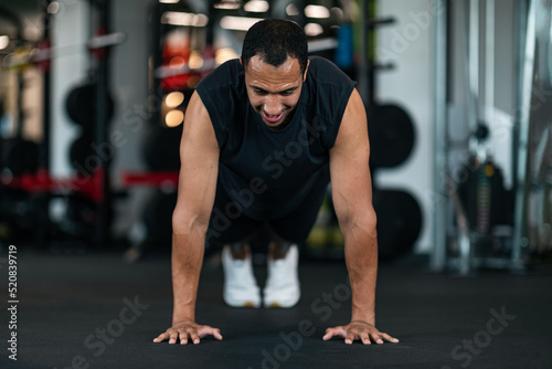 Athletic Black Man Making Floor Push Up Exercise While Training In Gym