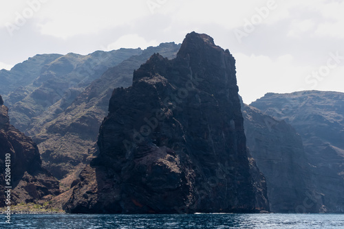 Panoramic view on the massive cliffs of Los Gigantes in Santiago del Teide, West coast Tenerife, Canary Islands, Spain, Europe. Rock formations along coastline of the Atlantic Ocean. Playa de Masca
