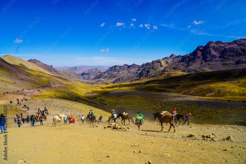Unidentified tourists walking on the Rainbow Mountain (Vinicunca Montaña de Siete Colores - Spanish) in Cusco, Peru
