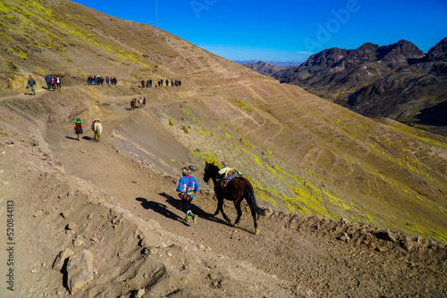 Unidentified tourists walking on the Rainbow Mountain (Vinicunca Montaña de Siete Colores - Spanish) in Cusco, Peru photo
