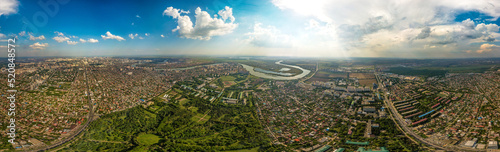 large aerial panorama (340 degrees) of the western outskirts of Krasnodar on a sunny summer day. Arboretum Park and the Kuban River