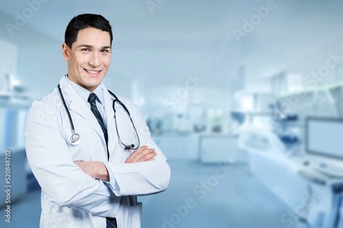 Portrait of young male doctor posing on the background