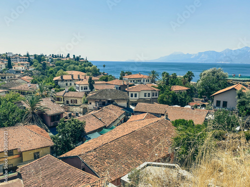 view from a height of a small settlement of local residents. small houses with tiled roofs. houses on a mountain hill with palm trees