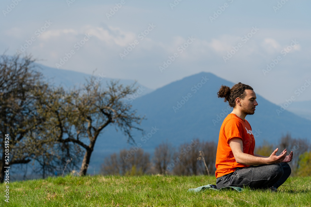 Young man do yoga on the rock peak. Meditation