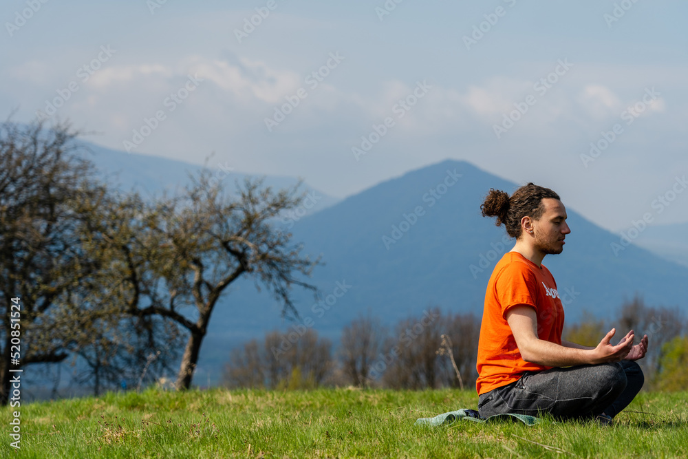 Young man do yoga on the rock peak. Meditation Young man do yoga on the rock peak. Meditation