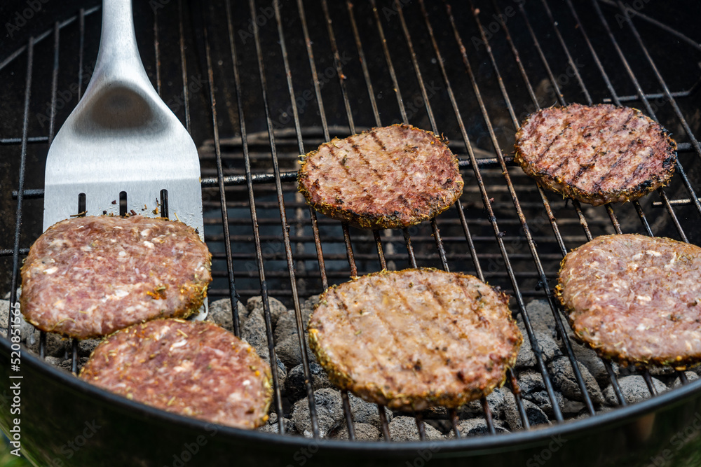 Selective focus of fresh delicious burger cutlets grilling on bbq grill