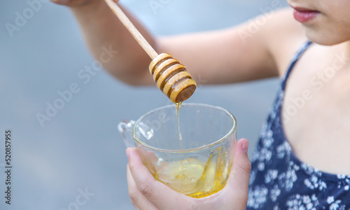A child eats honey in the park. Selective focus.
