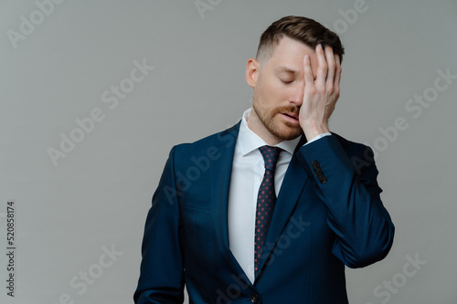 Depressed man in suit feeling sad while receiving bad news photo