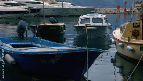 Empty boats.Creative.A landscape with rolling seas and small boats parked near the shore and mountains visible from behind.