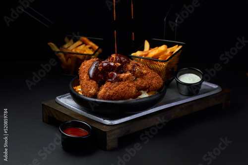 pollo frito sobre superficie metalica asado con salsa  photo