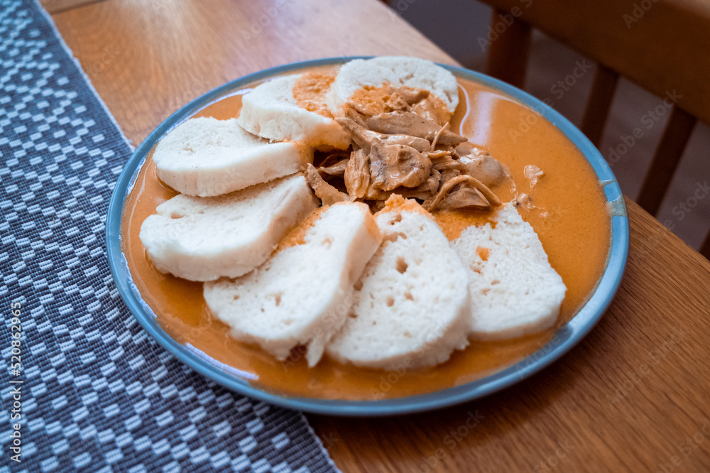 Traditional chicken hen on paprika or paprica creamy sauce with bread dumlings, typical czech food Traditional chicken hen on paprika or paprica creamy sauce with bread dumlings, typical czech food