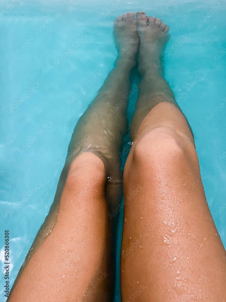 Woman legs bathing in the blue water