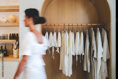 Blurred Sillhouette of a woman passing through neutral colored shop