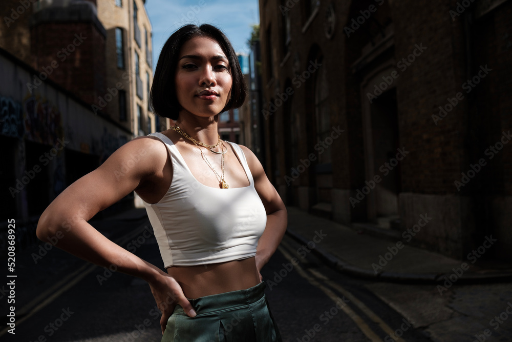 Close portrait of young asian woman looking at camera in a narrow street in London. Close portrait of young asian woman looking at camera in a narrow street in London.