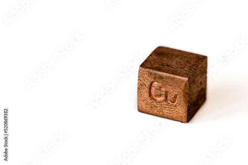 Copper cube with element name Cu on it on white background