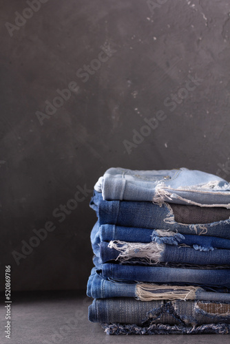 Blue jeans denim heap on table background. Jeans fabric heap as material surface