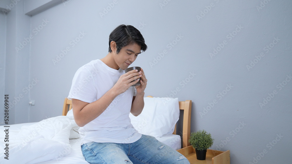 Holiday concept of 4k Resolution. Asian man drinking coffee happily in bedroom. fresh scent. Holiday concept of 4k Resolution. Asian man drinking coffee happily in bedroom. fresh scent.