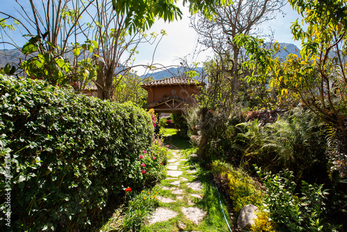 Corridor entrance in a rural house in the Peruvian Andes. Green corridor with stone path.