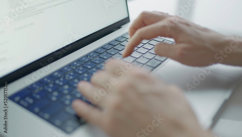 Close-up of hands typing text on laptop. Action. Beautiful hands print text on laptop. Writer or freelancer is typing on laptop