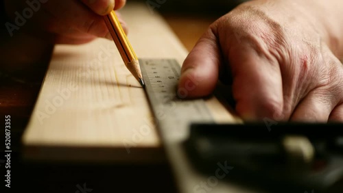Carpenter using square to measure on wooden background photo