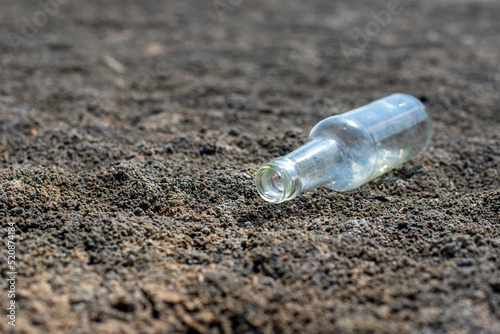 Glass bottle lying on the ground, The concept of lack of watter and drought land photo