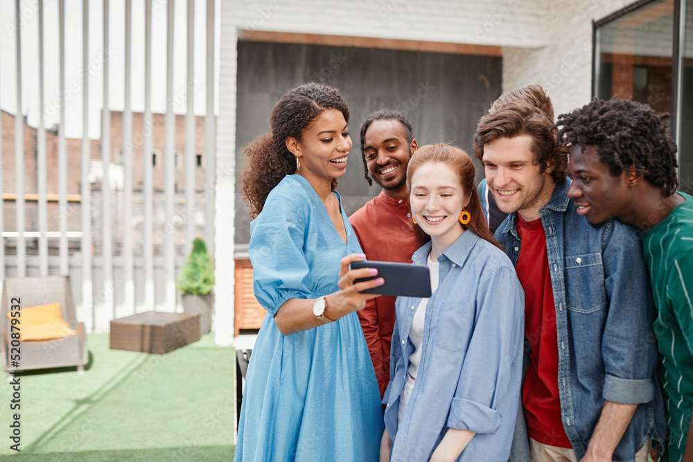 Portrait of diverse group of friends taking selfie photo at outdoor party or speaking by video chat, copy space Portrait of diverse group of friends taking selfie photo at outdoor party or speaking by video chat, copy space