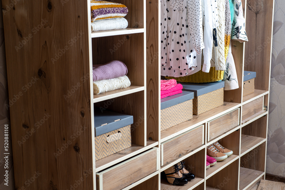 Big wardrobe with different clothes and accessories in dressing room