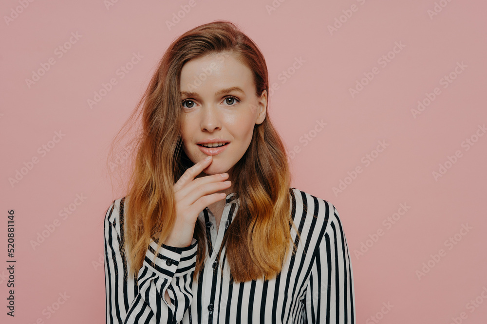 Excited young woman with open mouth holding hand on chin Excited young woman with open mouth holding hand on chin