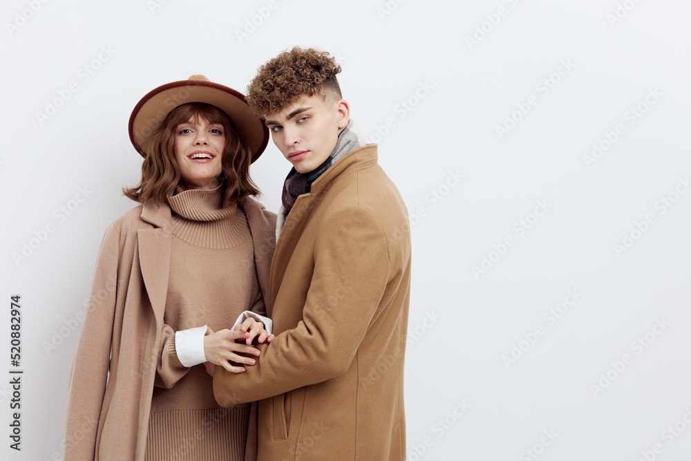 a sweet, beautiful, loving couple stands on a white background in stylish beige autumn clothes, gently embracing each other a sweet, beautiful, loving couple stands on a white background in stylish beige autumn clothes, gently embracing each other