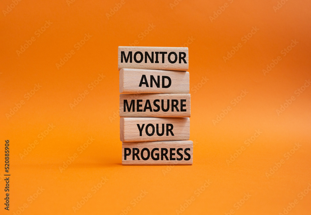 Monitor and Measure your Progress symbol. Wooden blocks with words