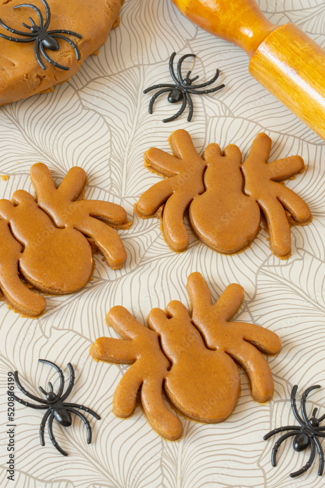 Cutting Halloween gingerbread in shape of spiders