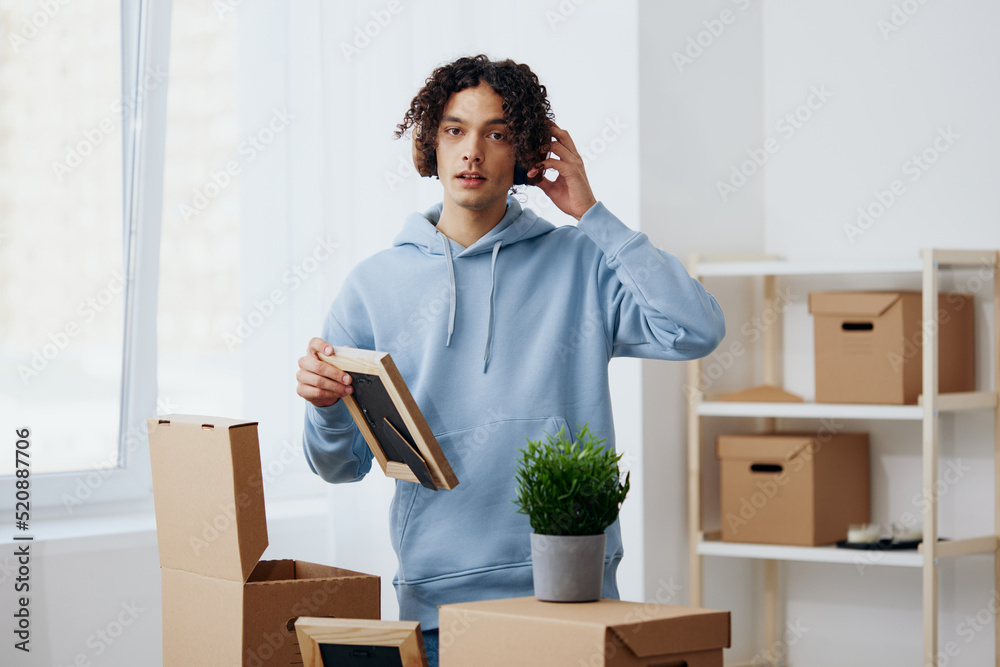 portrait of a man unpacking things from boxes in the room sorting things out portrait of a man unpacking things from boxes in the room sorting things out