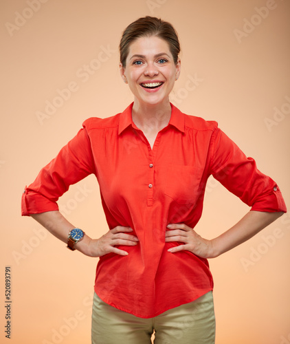 Smiling young lady in red shirt standing with hands n waist isolated portrait. photo