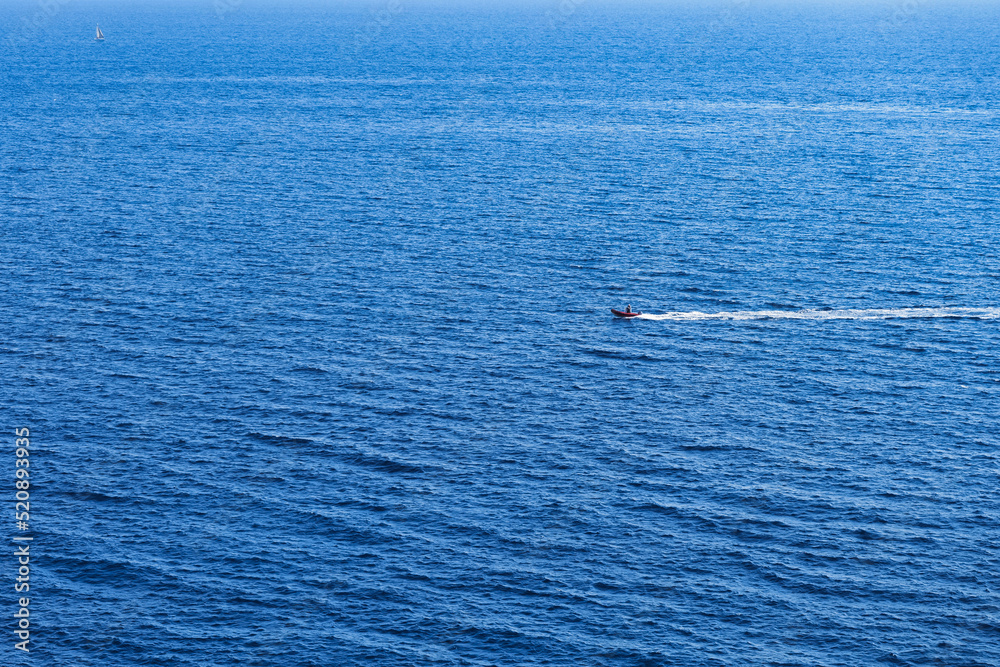 Motor boat on the deep blue ocean. RIB rigid inflatable boat crossing ...