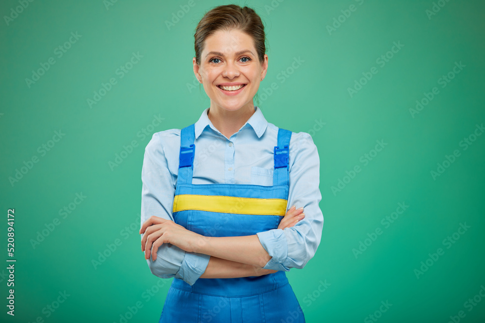 woman worker in overalls with arms crossed. isolated on green background. woman worker in overalls with arms crossed. isolated on green background.
