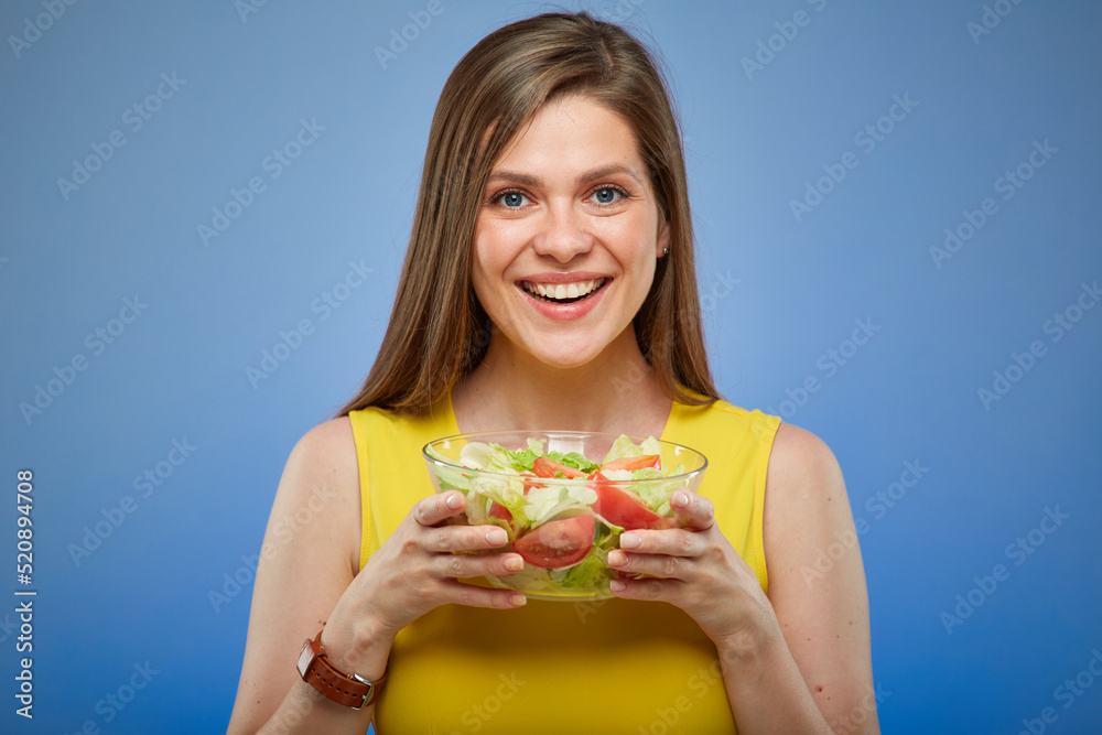 Smiling young lady in yellow dress holding glass bowl with salad. isolated female portrait. Smiling young lady in yellow dress holding glass bowl with salad. isolated female portrait.