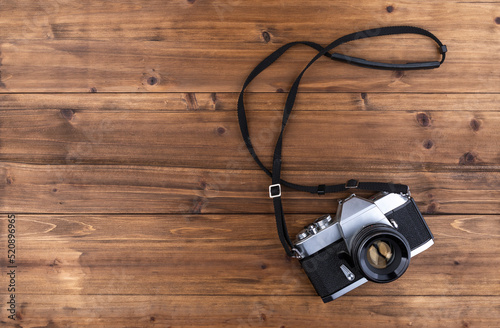 Vintage, 35mm film camera on wooden background with space