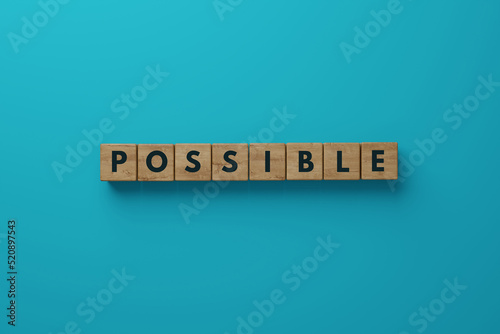 Wooden blocks on a blue background with the word Possible. The concept of success in life, business. 3d render