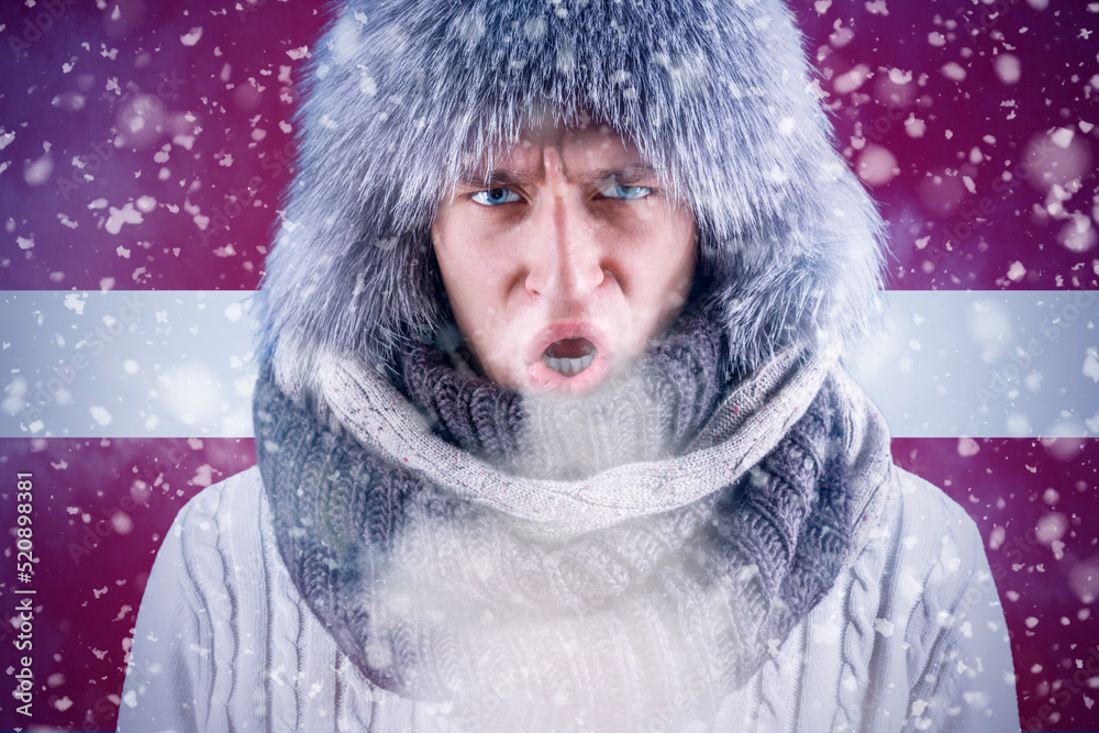 Isolate. Cold weather. Bask. A man in a fur hat and scarf warms his hands with his mouth. It's winter time Isolate. Cold weather. Bask. A man in a fur hat and scarf warms his hands with his mouth. It's winter time