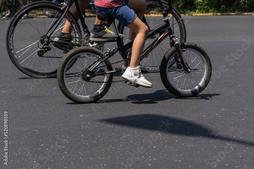 young man with customized bicycle shows off his style riding down the street on a sunny day.