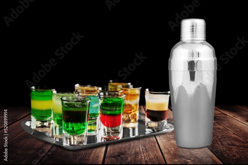 Cocktail shaker and martini cocktails on desk background