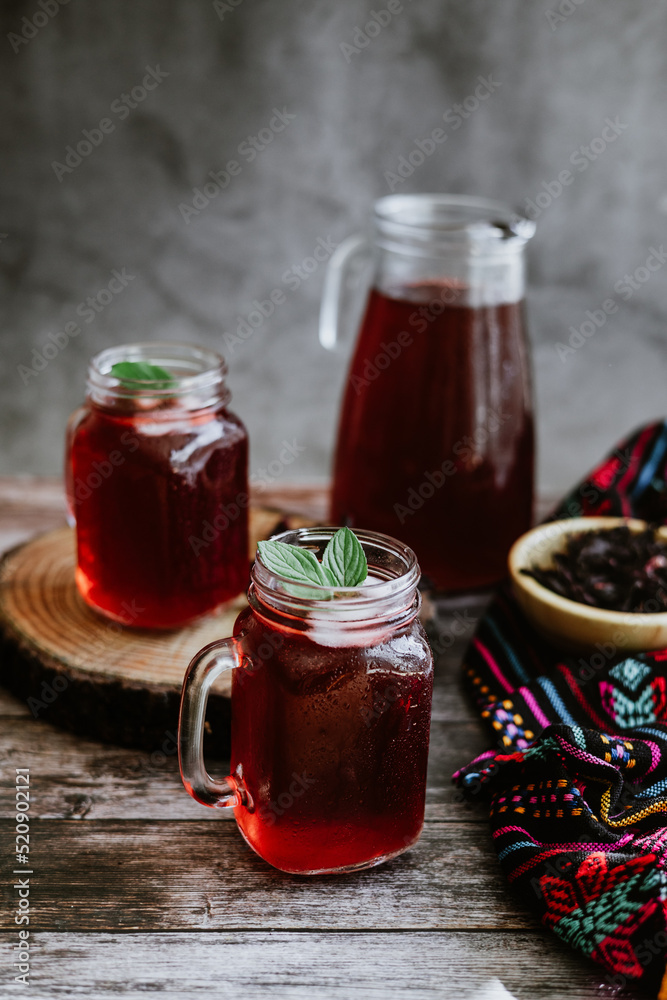 Agua de Jamaica or roselle mocktail drink, summer beverage in mexico with ice and dry hibiscus petals on table background
Agua de Jamaica or roselle mocktail drink, summer beverage in mexico with ice and dry hibiscus petals on table background