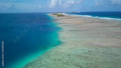 Majuro, Marshall Islands. Small tropical uninhabited island in the middle of the pacific ocean. Atoll with beautiful sandy beach surrounded by coral reef with palm trees. Aerial footage photo