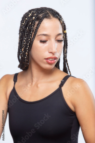 Studio portrait of beautiful Latina woman with long braids.